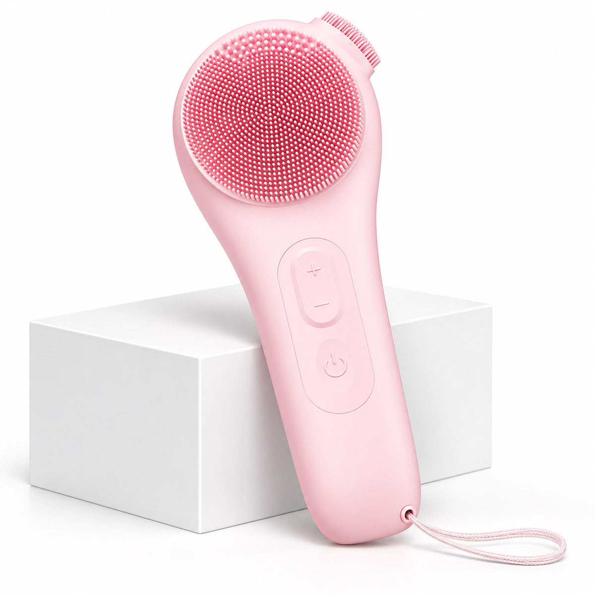 VanqHeal pink silicone facial cleansing brush with dual-texture bristles, vibration controls and wrist strap.